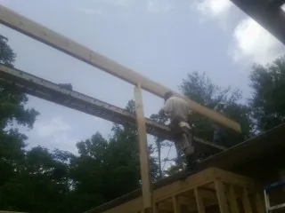 Carpenter setting a ridge beam over a new addition frame — Ice Dam Removal by Roofing Brothers in Mutual