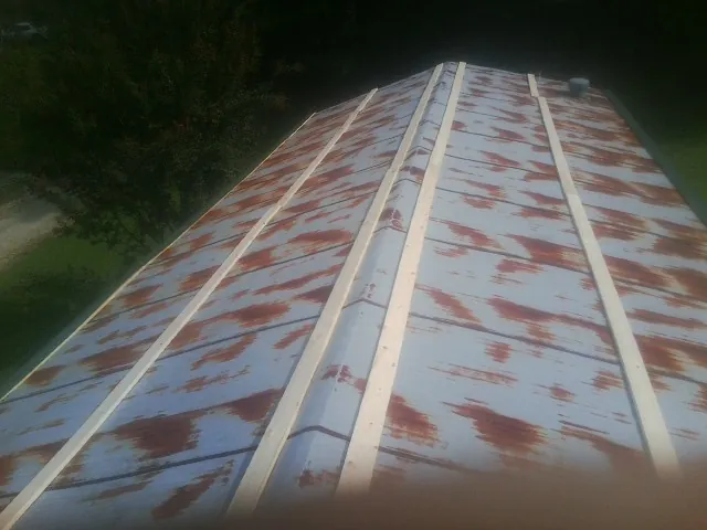 Rusted metal roof panels with new wood purlins before replacement — Storm Damage Roof Repair in Mutual by Roofing Brothers