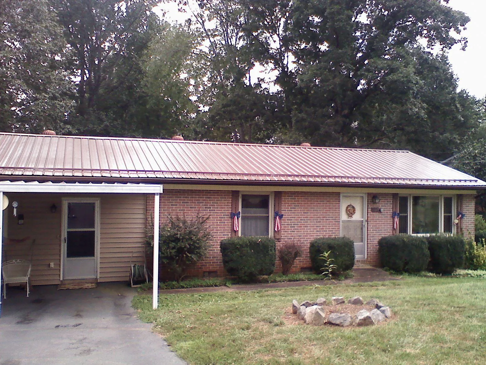 Bronze metal roof and carport on a brick ranch home — Roof Repair work by our crew in Mutual
